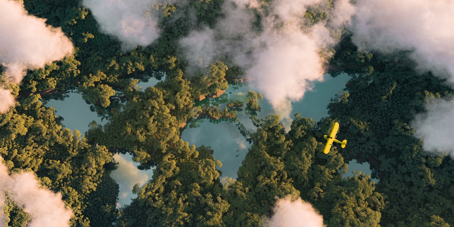 Kaukainen ilmakuva tiheästä sademetsäkasvillisuudesta, jossa järvet ovat maailman mantereiden, pilvien ja yhden pienen keltaisen lentokoneen muotoisia.