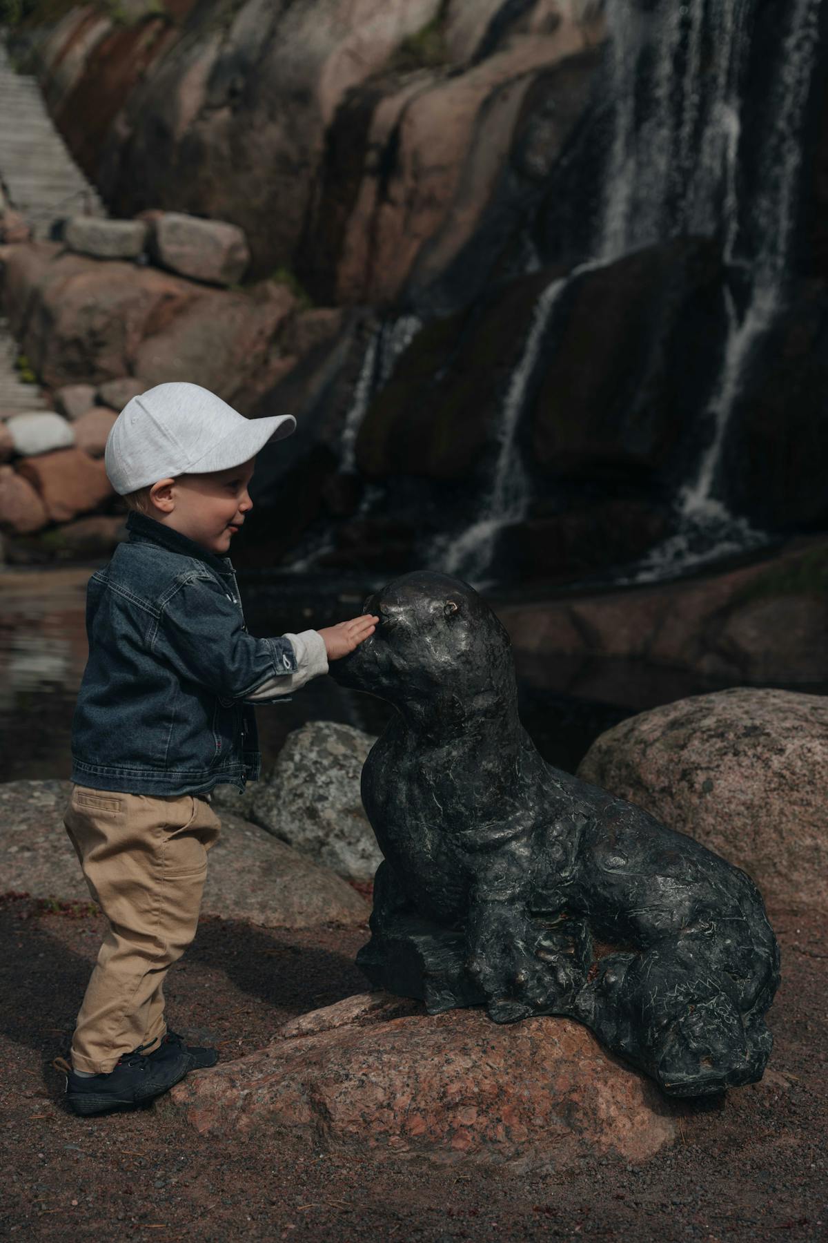 Lapsi bongailemassa patsaseläimiä Kotkan puistossa.