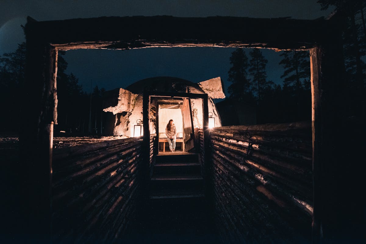 Vironlahdella sijaitseva bunkkerimuseo, jossa nainen ihastelee illan hämärtyessä bunkkereita 